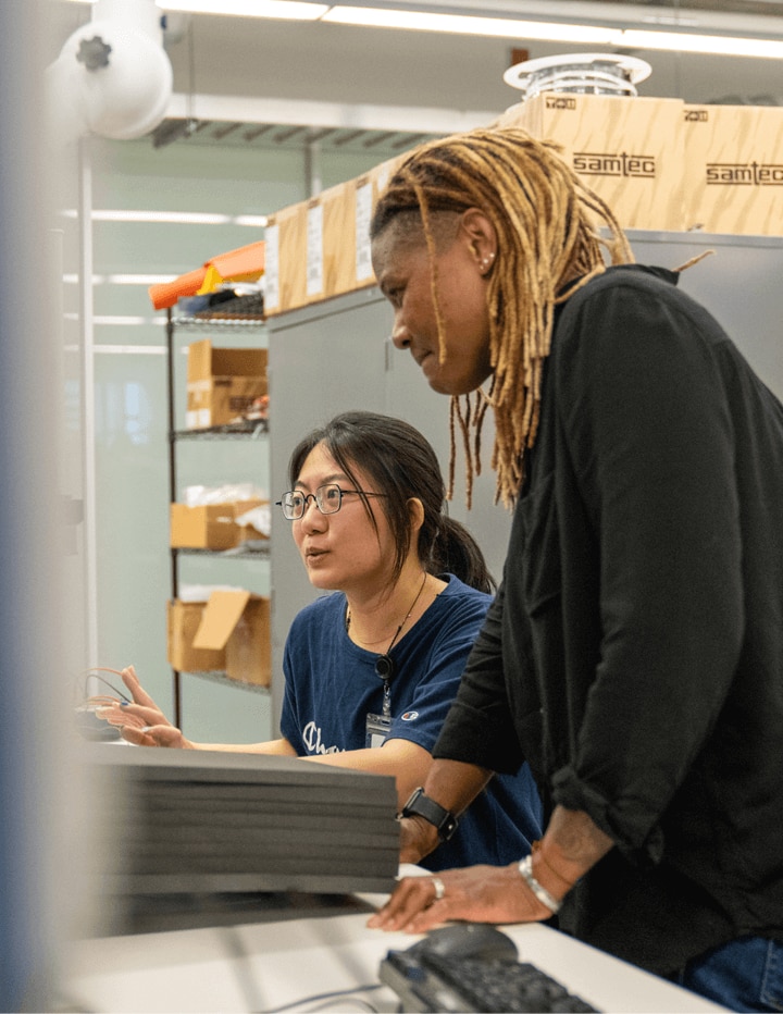 Two Diverse Employees Work in a Lab